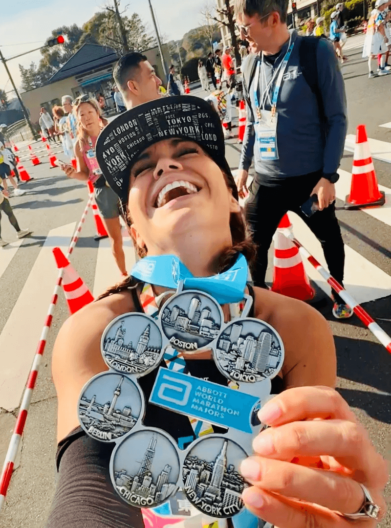 Carleth smiling and holding the 6 majors marathon medal